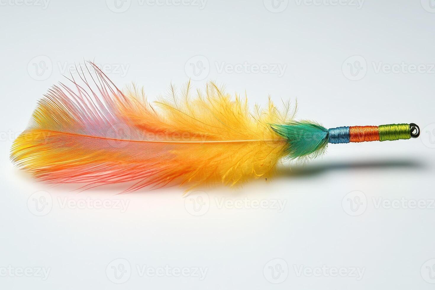 A colorful feather with a green, yellow and orange tail photo
