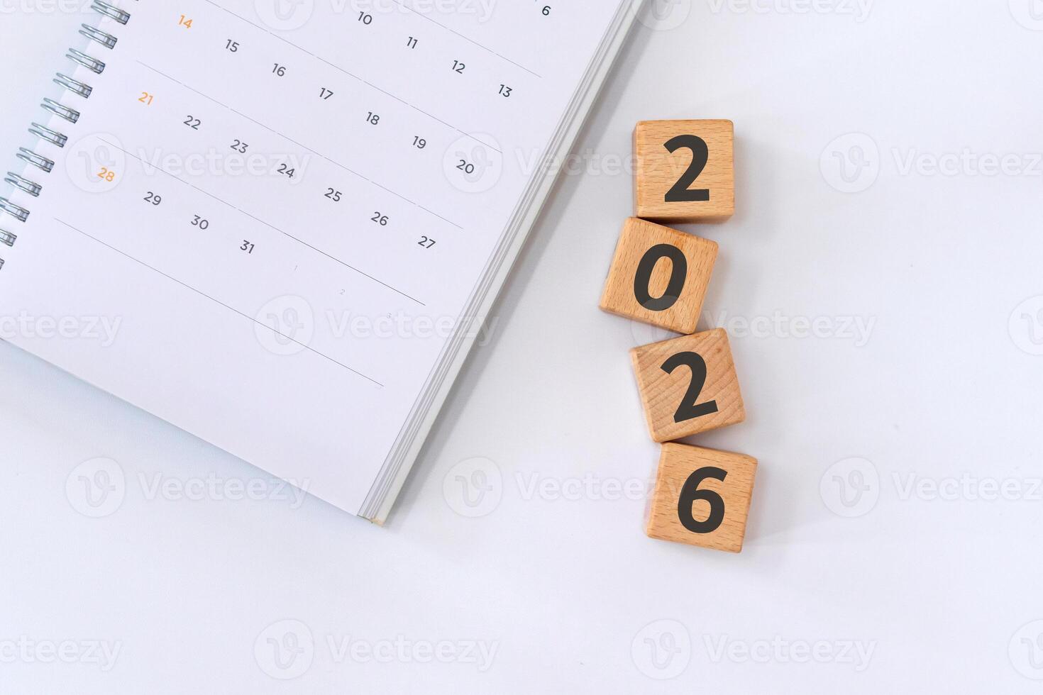 Calendar on notebook and 2026 written on wooden blocks. New year 2026 concept. New year's resolution. photo
