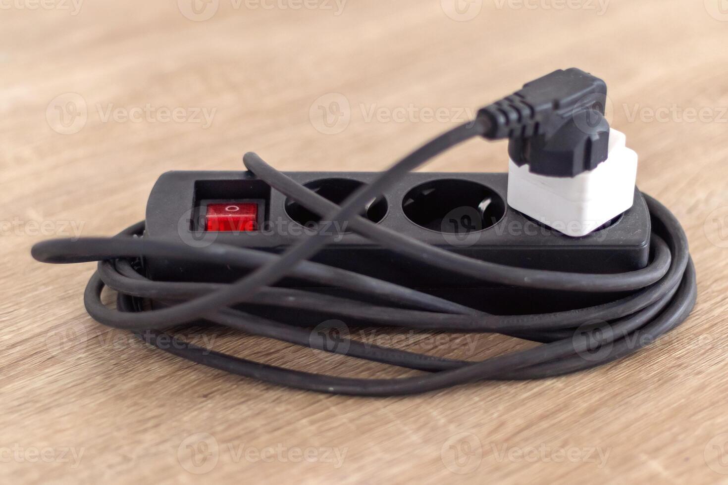 An electrical extension cord socket on wooden table photo