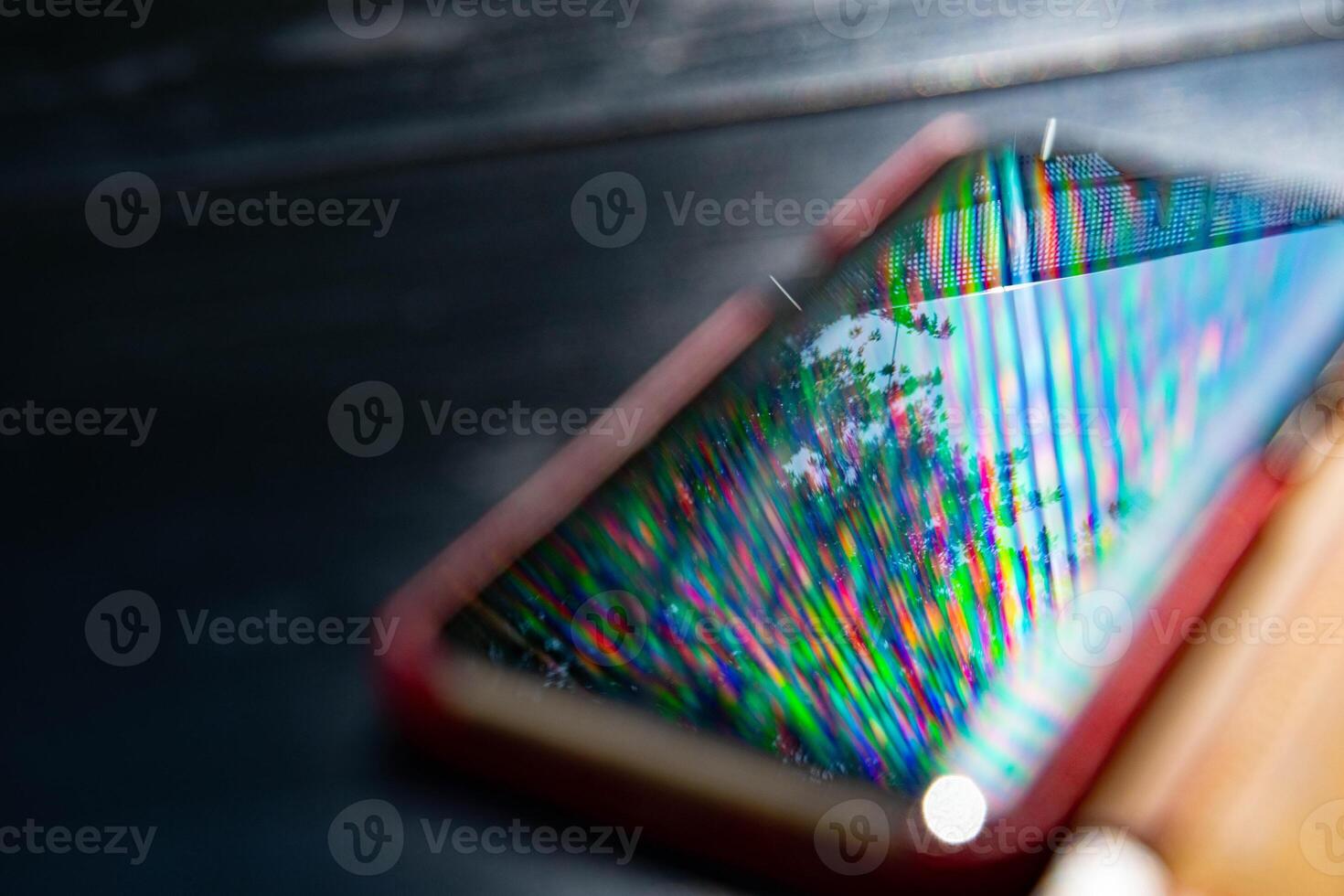 Rainbow blur reflection in glossy surface of smartphone photo