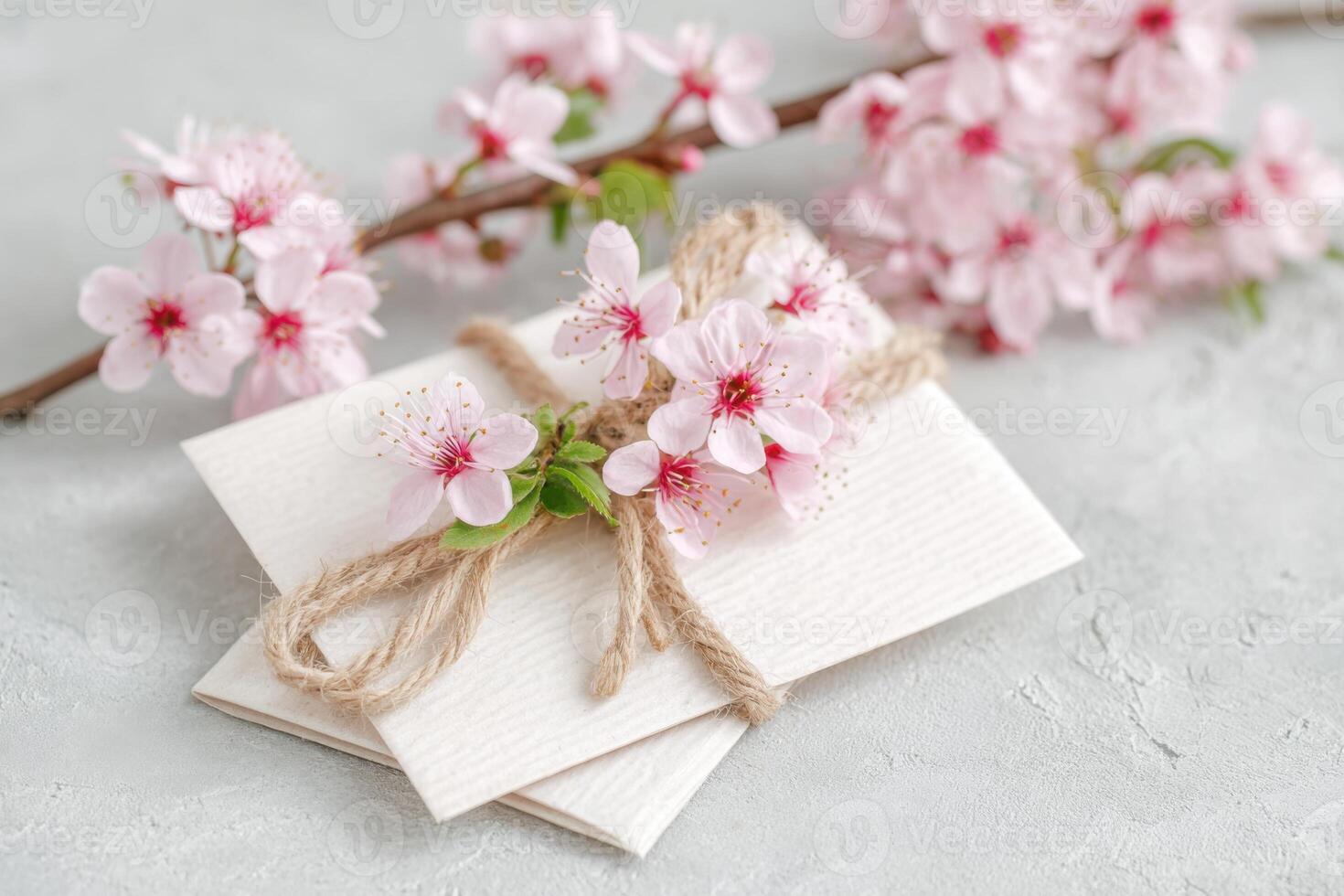 Elegant floral arrangement featuring delicate pink blossoms tied with twine on textured surface, creating a serene and inviting atmosphere for spring celebrations and personal notes photo
