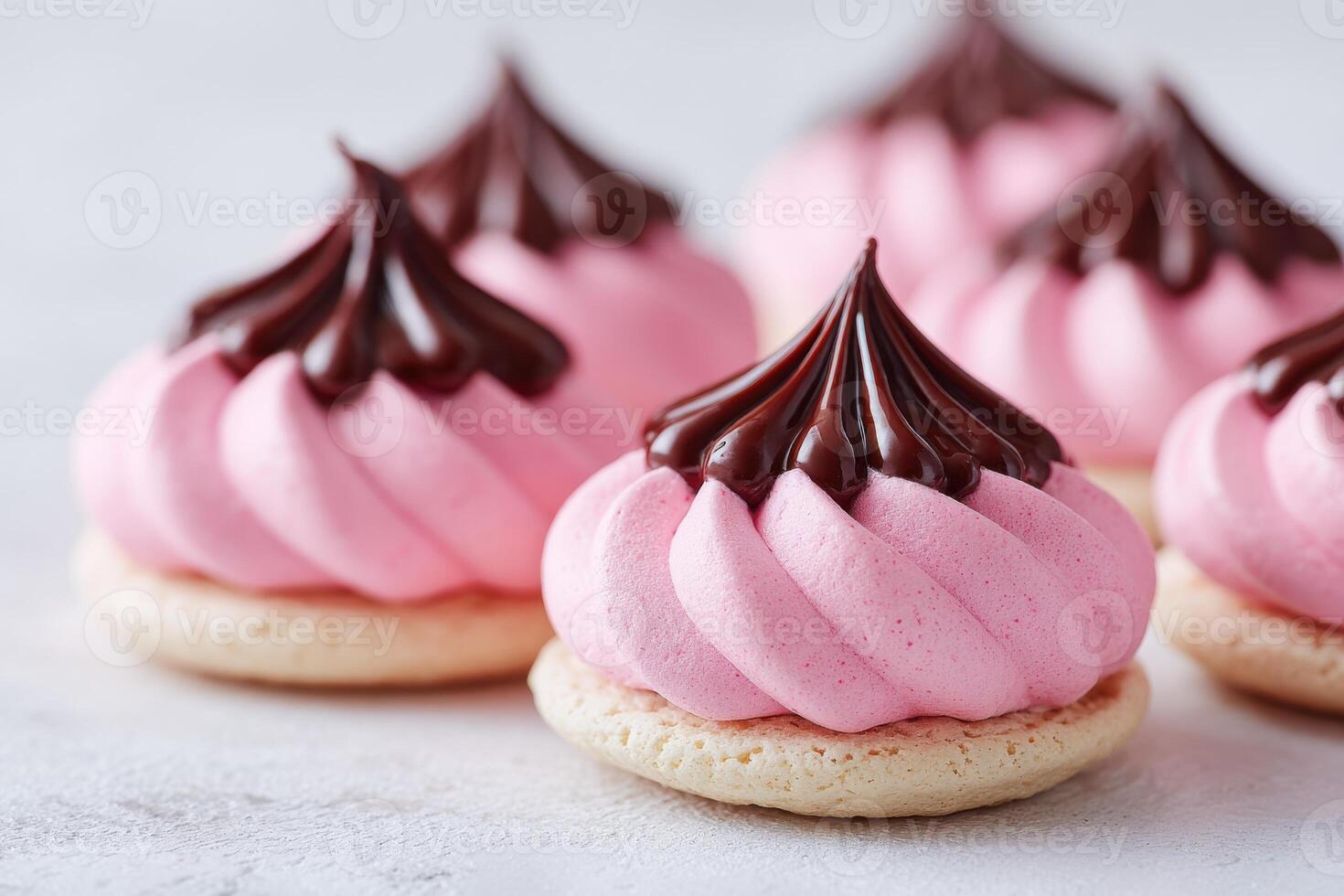 Pink meringue cookies with chocolate topping arranged beautifully on a light surface, showcasing delightful textures and vibrant colors, perfect for dessert lovers and culinary enthusiasts photo