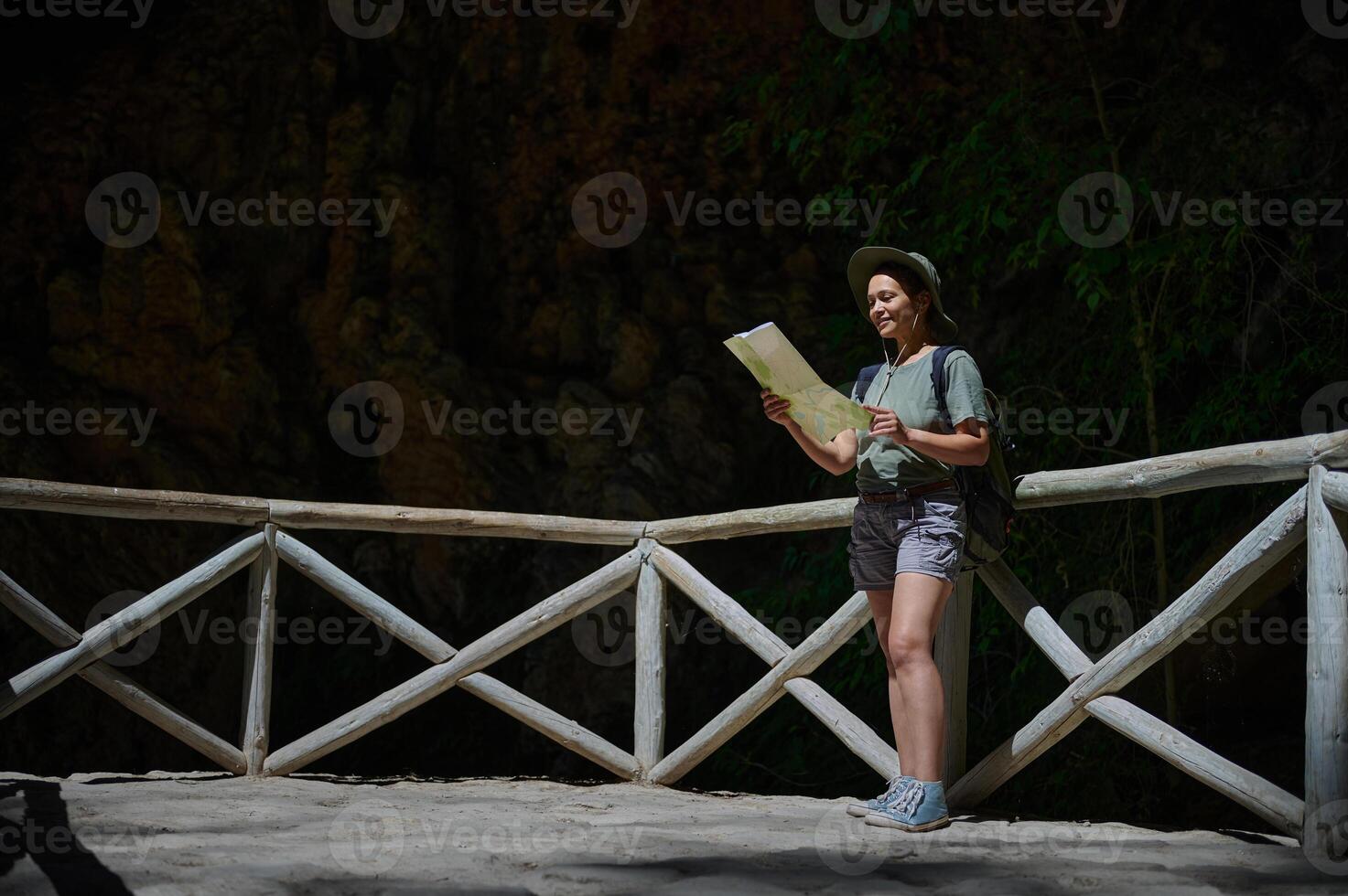 Woman Exploring Hiking Trail in Nature Holding Map on Sunny Day photo