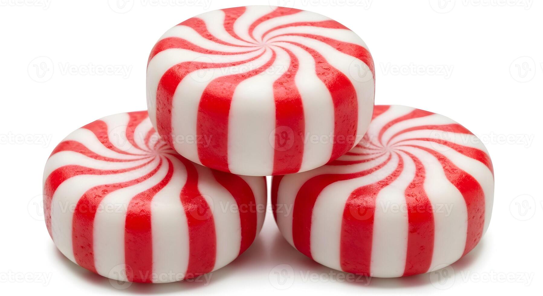 A close up of a stack of three peppermint candies with red and white stripes on a black background photo