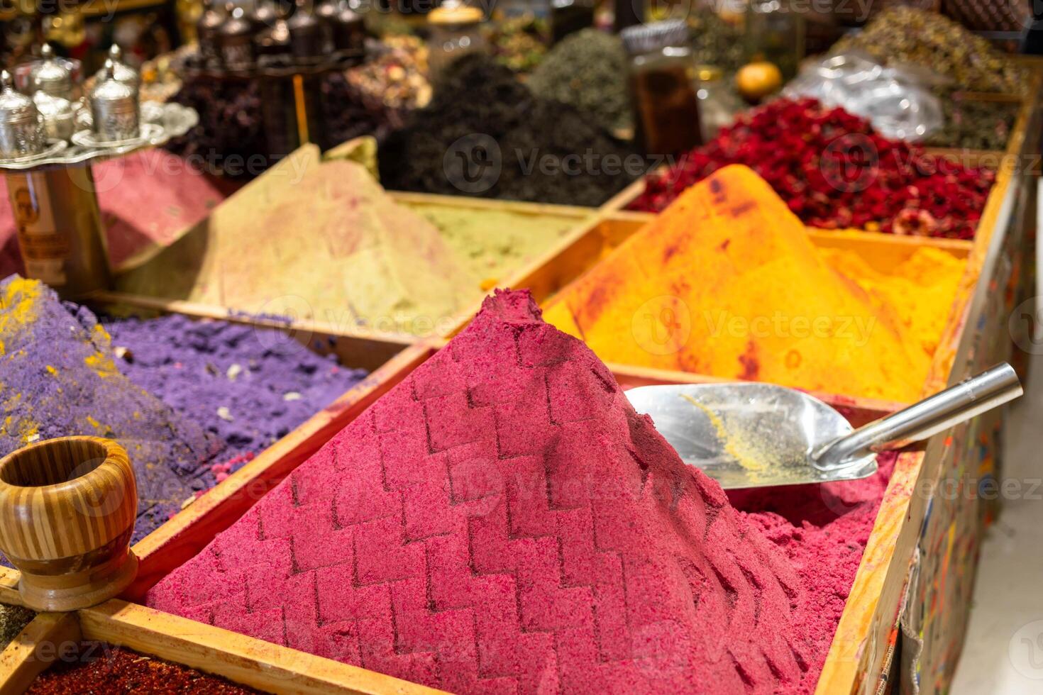 Colorful spices arranged in wooden containers at a vibrant market showcasing rich textures and hues photo