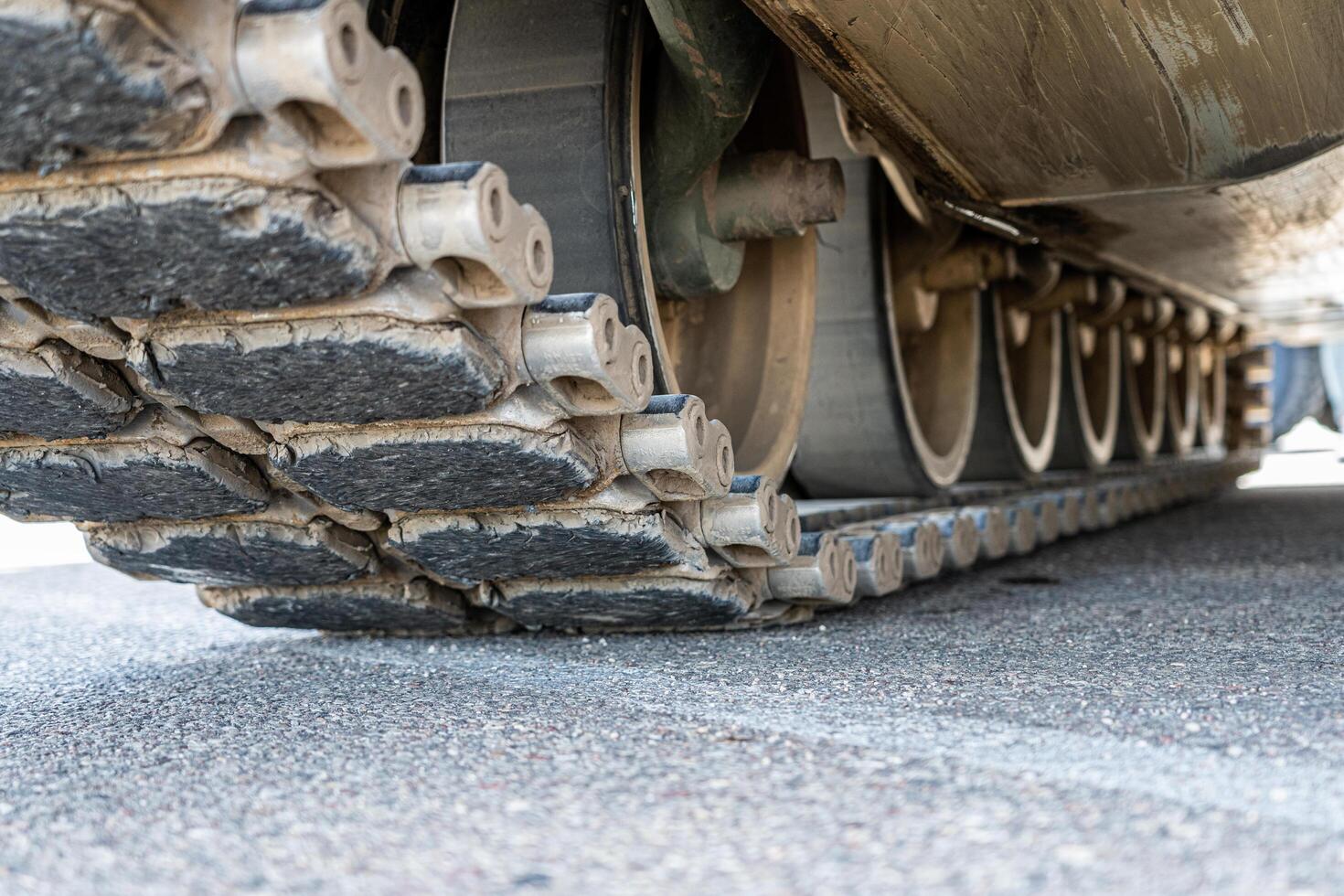 Tank track close-up view from the bottom on asphalt photo