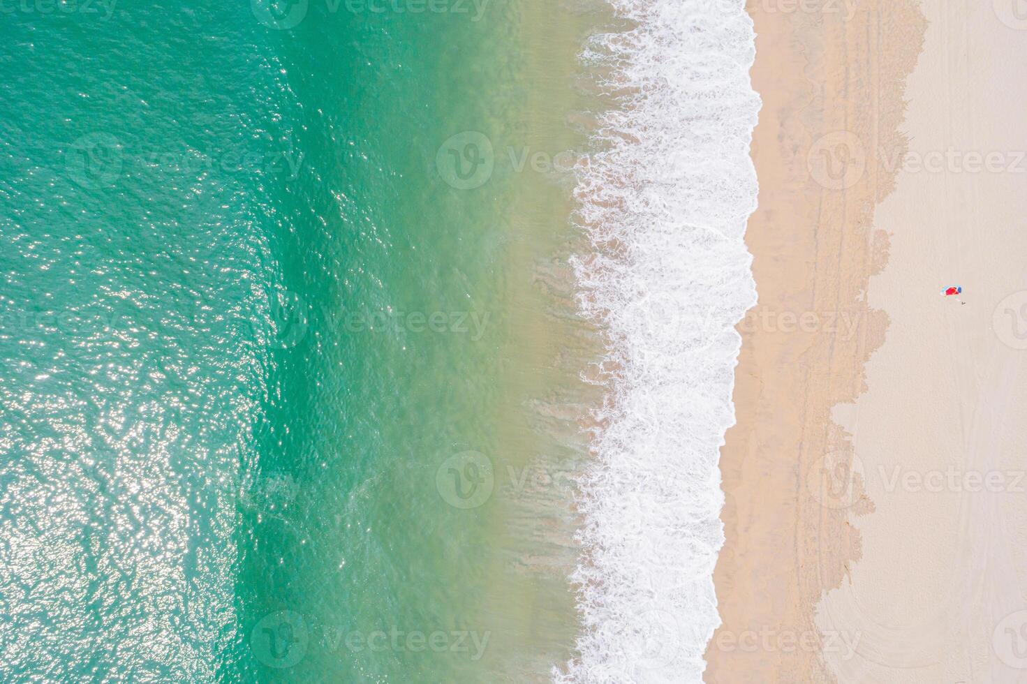 top down drone shot of turquoise ocean and a solitary red accent on a paradise beach, aerial drone view photo
