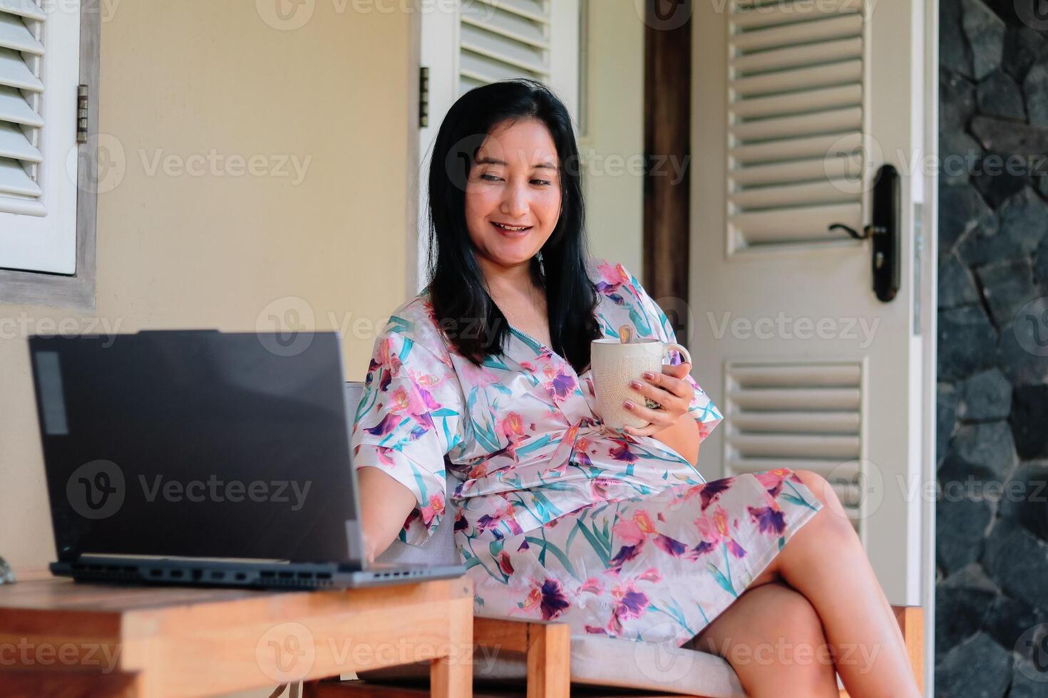 Relaxed morning work routine with coffee and floral robe. photo