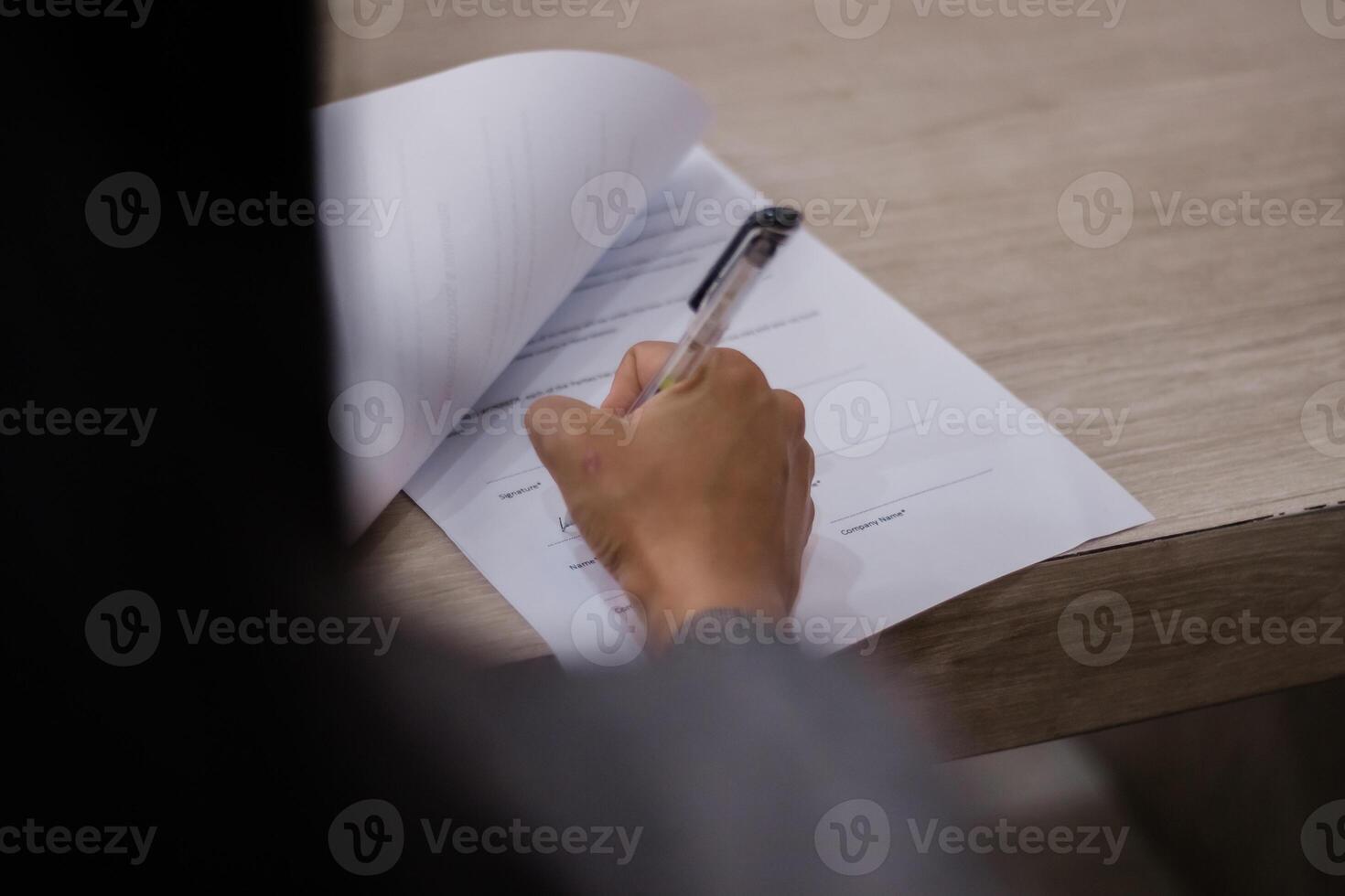 Signing a contract, close-up shot of hand with pen filling out o photo