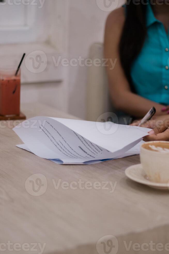 Signing documents with beverage at hand, business meeting in caf photo