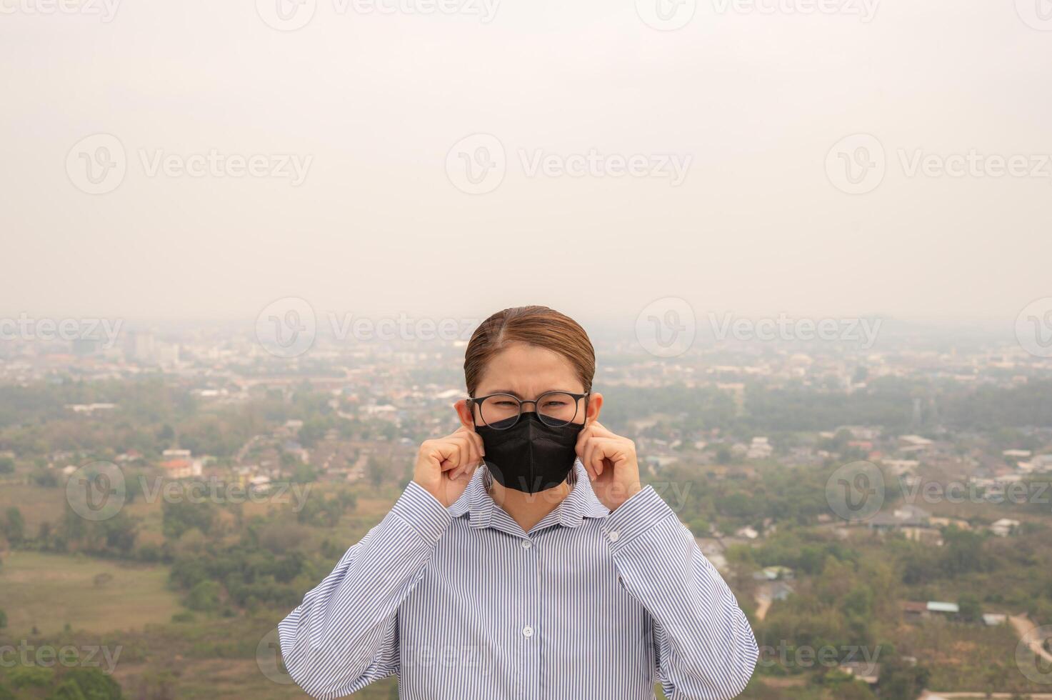 Asian businesswoman wearing N95 mask for protect Bad air pollution covered her town. photo