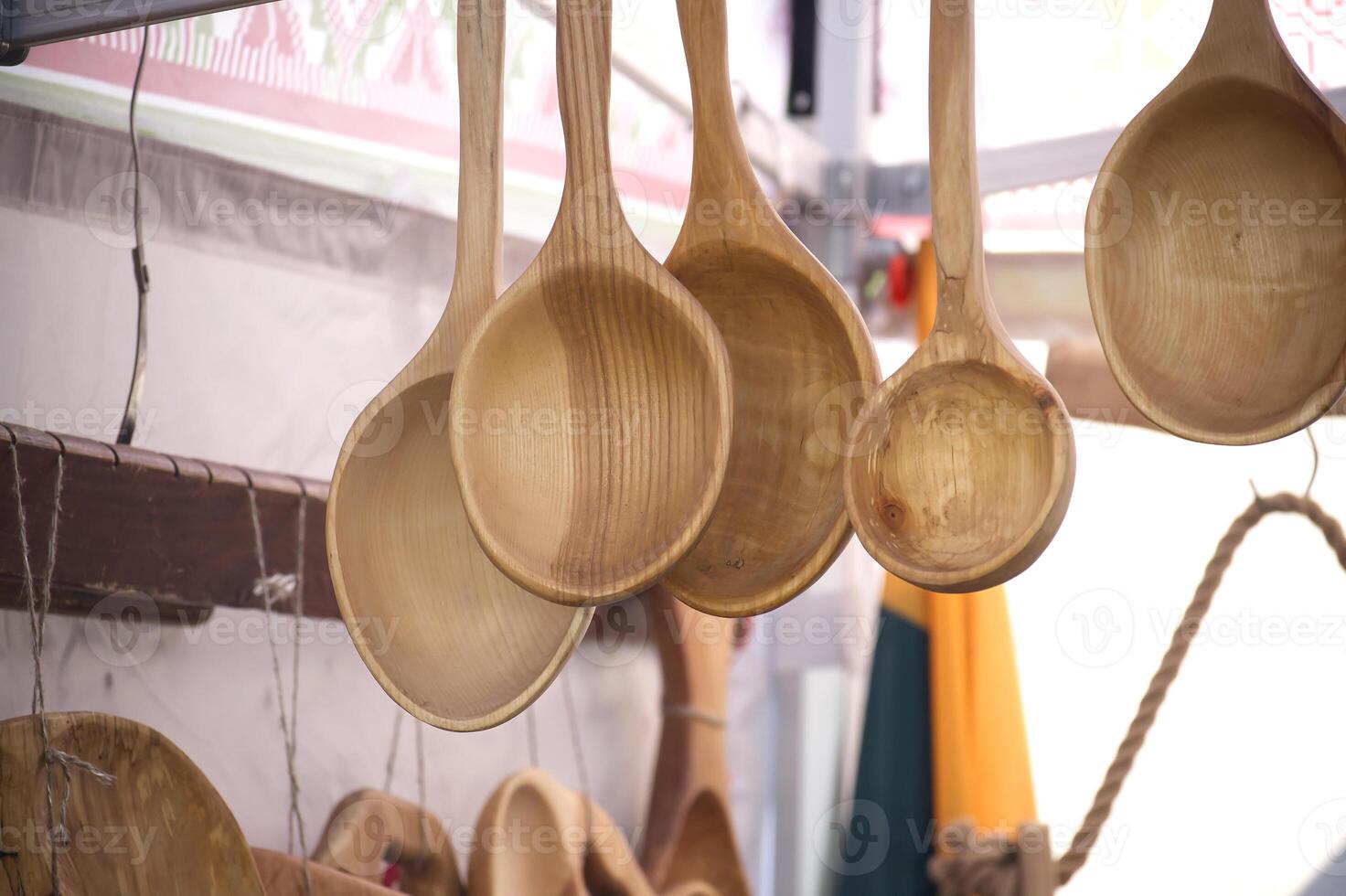 Handmade wooden spoons hanging at the fair showcase local artisan craftsmanship, natural wood grain. photo