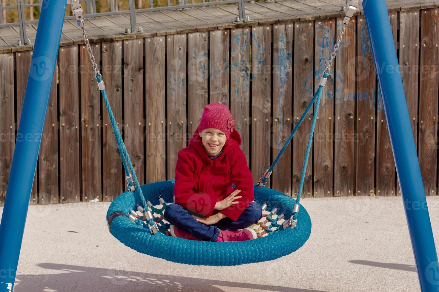 Happy 8 9 Year Old Kid on Round Seesaw Looking at Camera photo