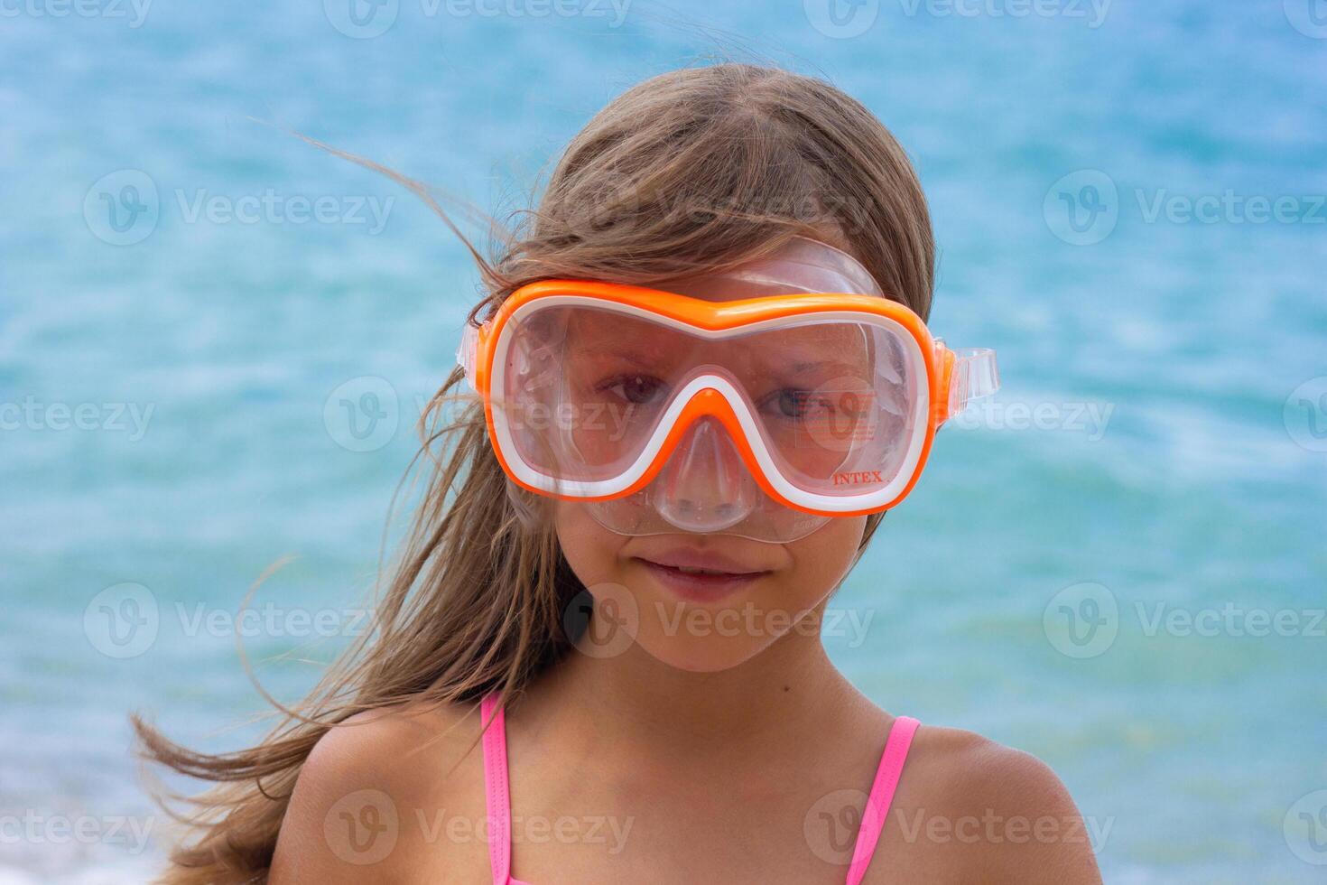 Portrait of caucasian child of 7-8 years in swimming mask looking at camera photo