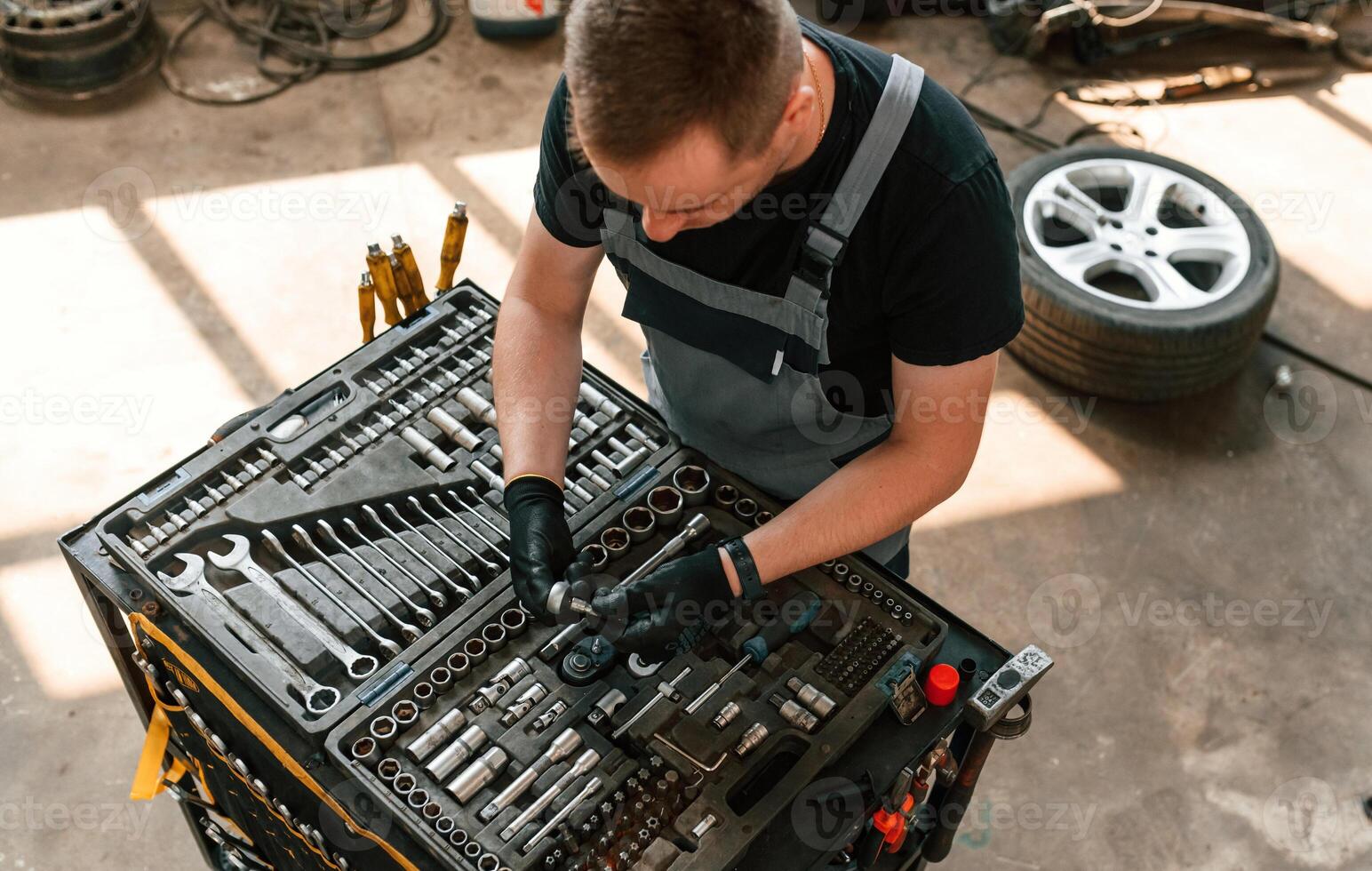 Standing by the toolbox,. Man, is works in the automobile repairing salon photo
