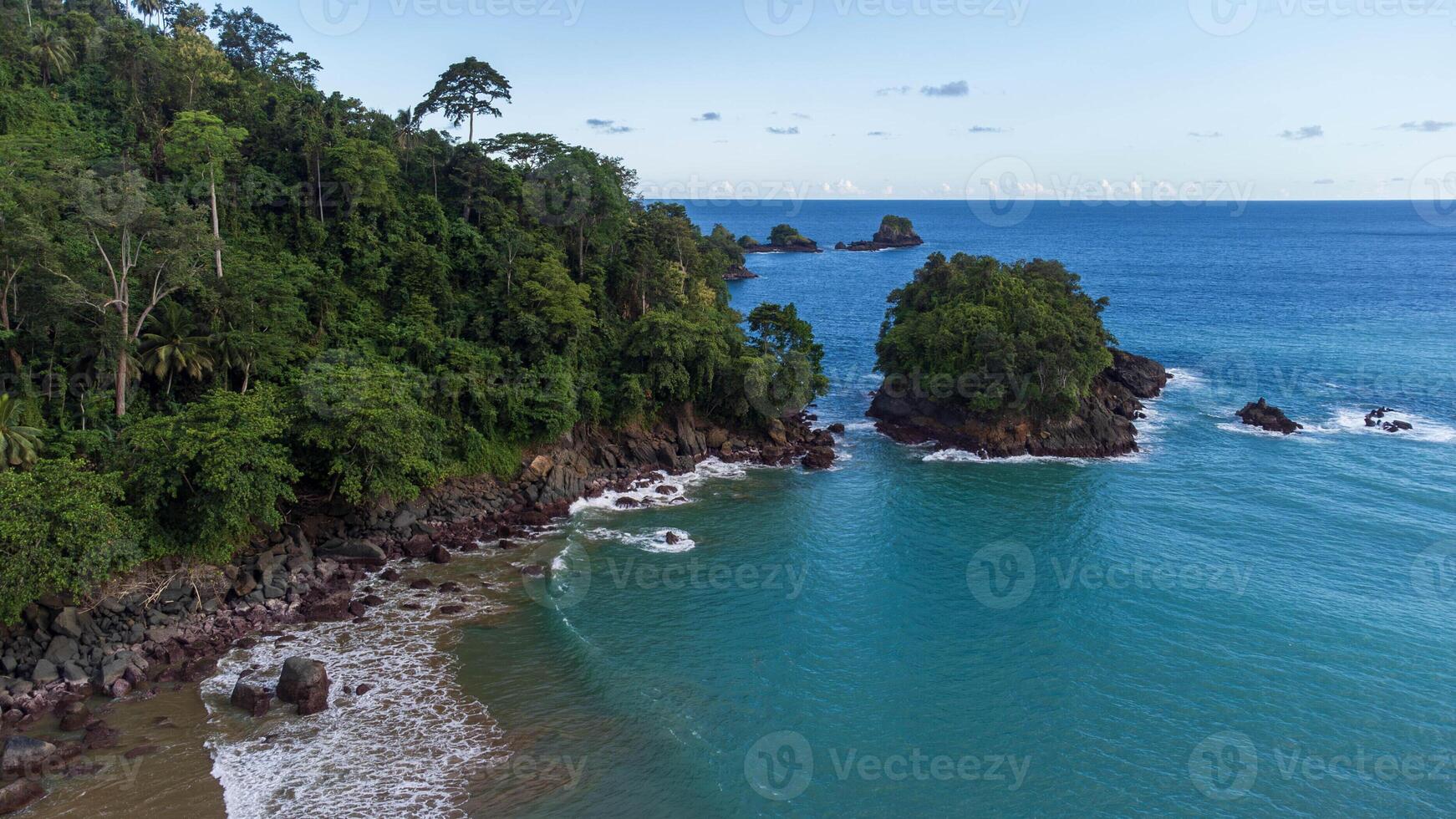 Scenic coastal view with turquoise waters, lush greenery and small islands at Lenggoksono Beach photo