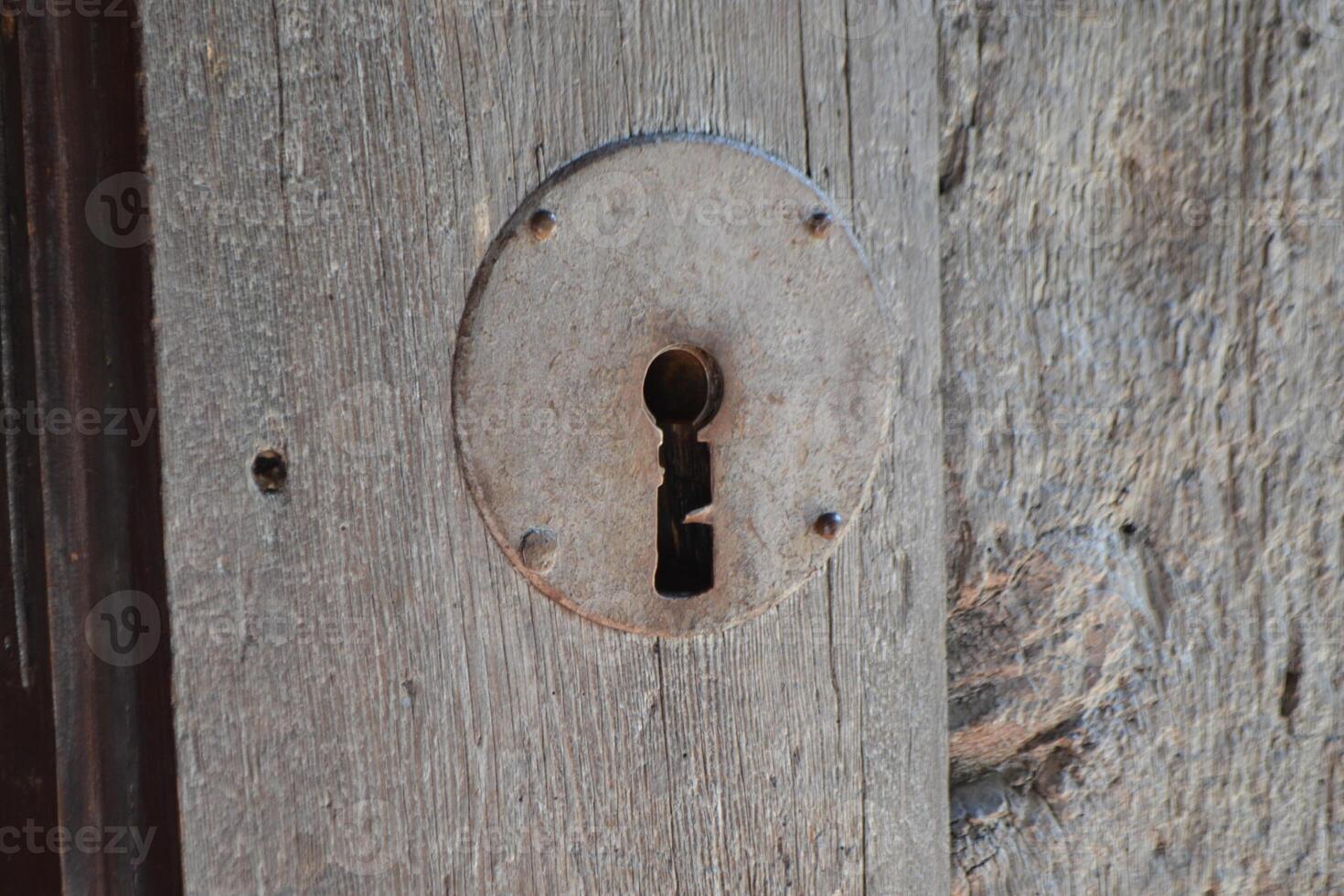 Rustic keyhole on weathered wooden door in Brihuega spain for architectural design and historic decor. Iglesia de San Felipe. Church Saint Felipe in Brihuega, Guadalajara, Spain photo