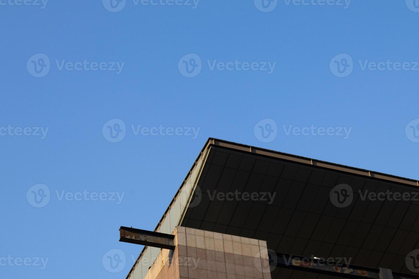 A close-up view of the rooftop edge of a high-rise building on a clear day. photo