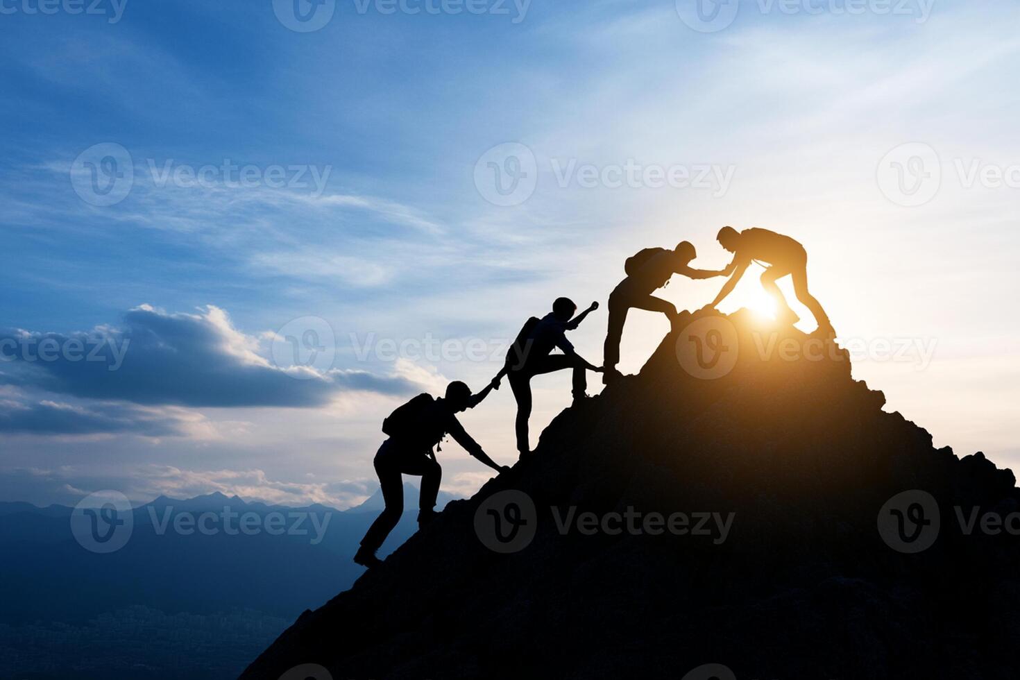 Silhouette of people climbing a mountain to reach the sun photo
