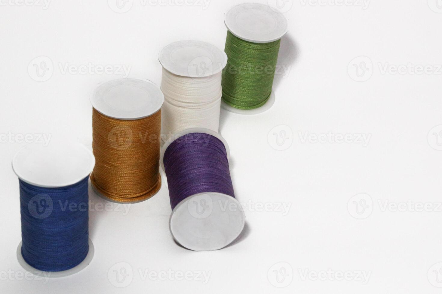 Spool of sewing thread, isolated on white background. Colored yarns used by factories in the clothing industry. Threads wound on the spool. Colored reels photo