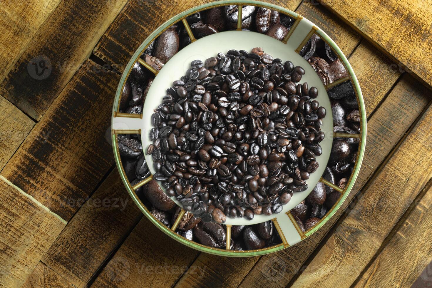 Top view of coffee beans dish on wooden background photo