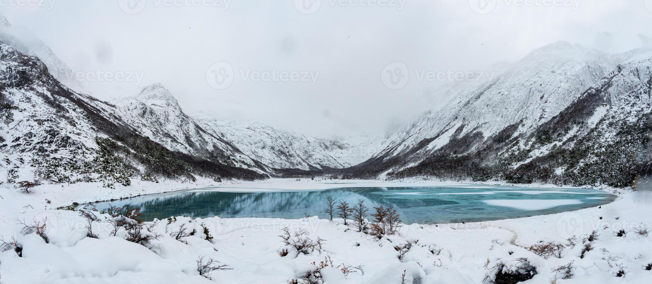 Aerial view of glacier water Emerald Lake in the mountain summit. Turquoise color water lake surrounded by forest and rocky mountain peaks. photo