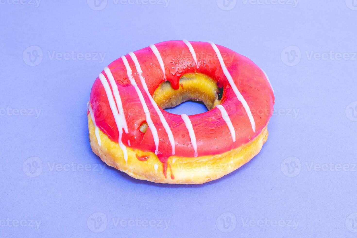 Single donut with topping laying on a blue background. photo