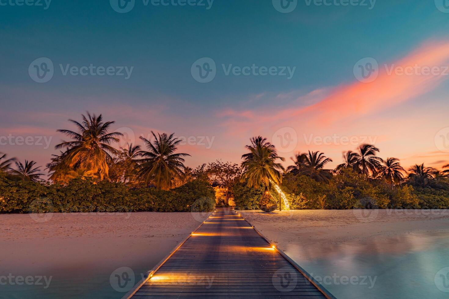 Sunset on Maldives island, luxury water villas resort and wooden pier. Beautiful sky and clouds and beach background for summer vacation holiday and travel concept. Paradise sunset landscape photo