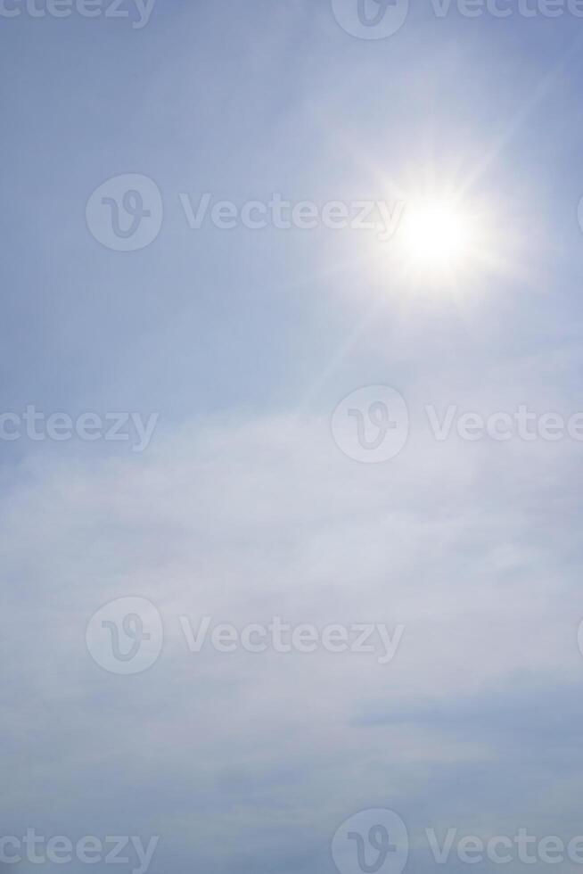 blue sky background with clouds, vertical. Bright sun photo