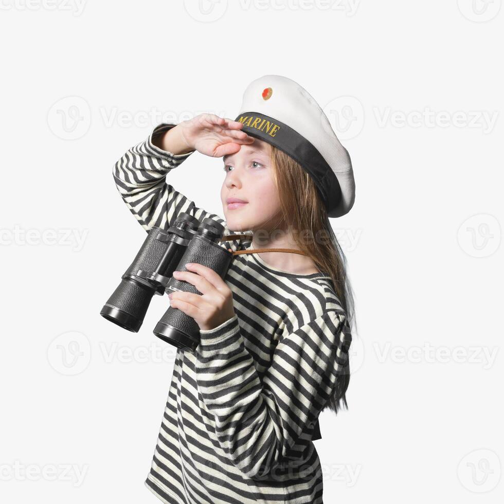 Portrait of a sailor girl on a white background teenage girl in a sailor suit with a binocular looking into the distance. photo