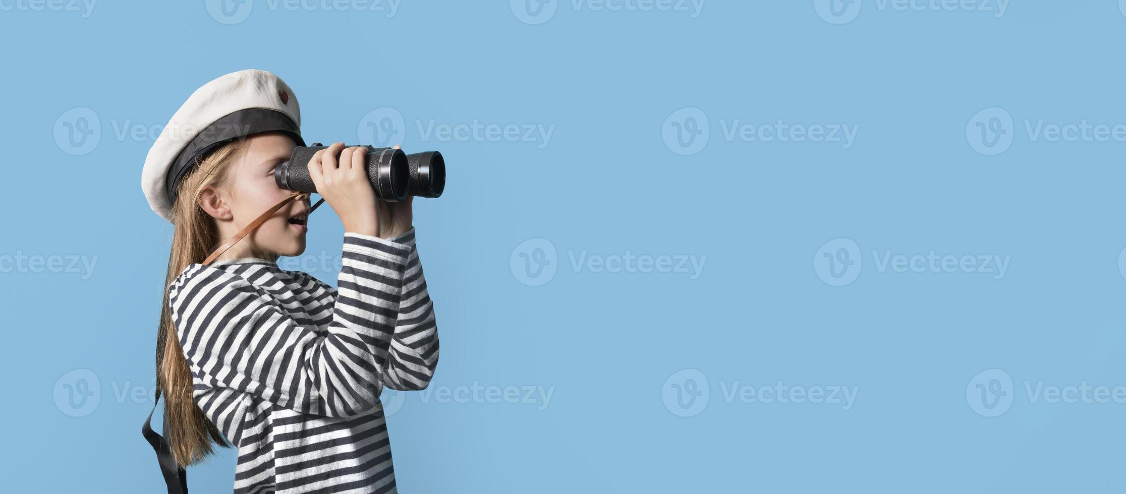 Banner-portrait of a sailor girl on a blue background teenage girl in a sailor suit with a binocular looking into the distance photo