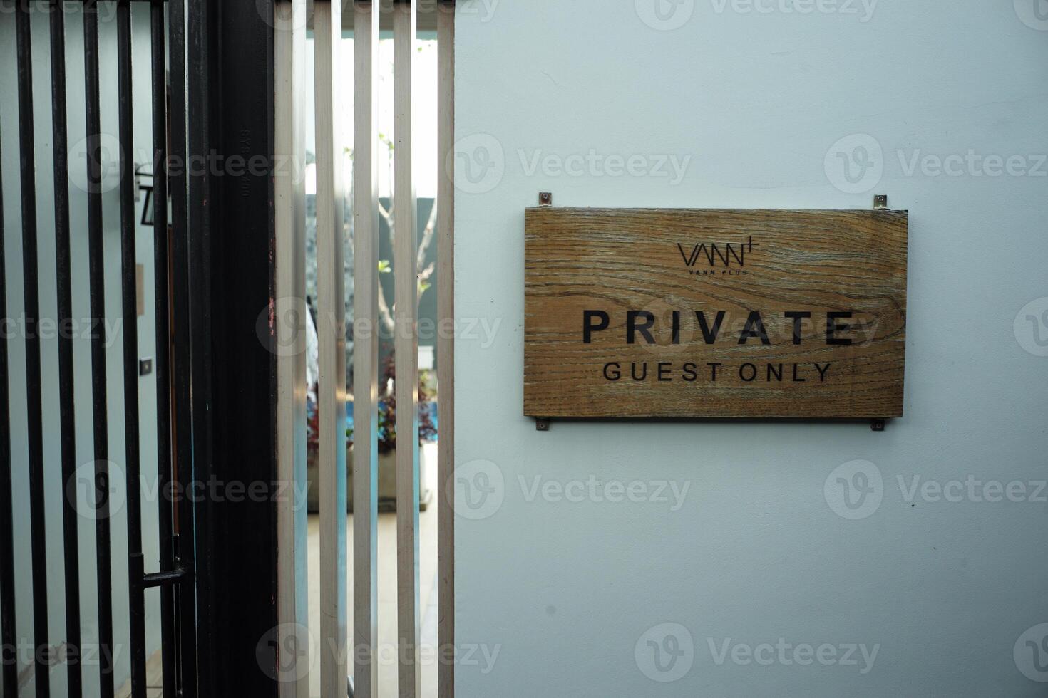The wooden signboard with the words Private Guest Only hanging on the white wall photo