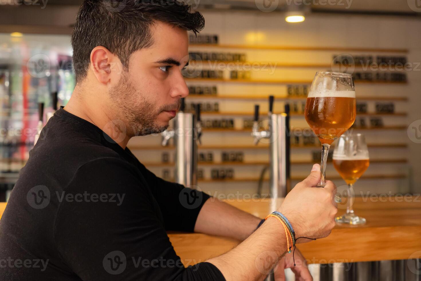 Latino man enjoying craft lager beer, savoring flavor and quality. photo