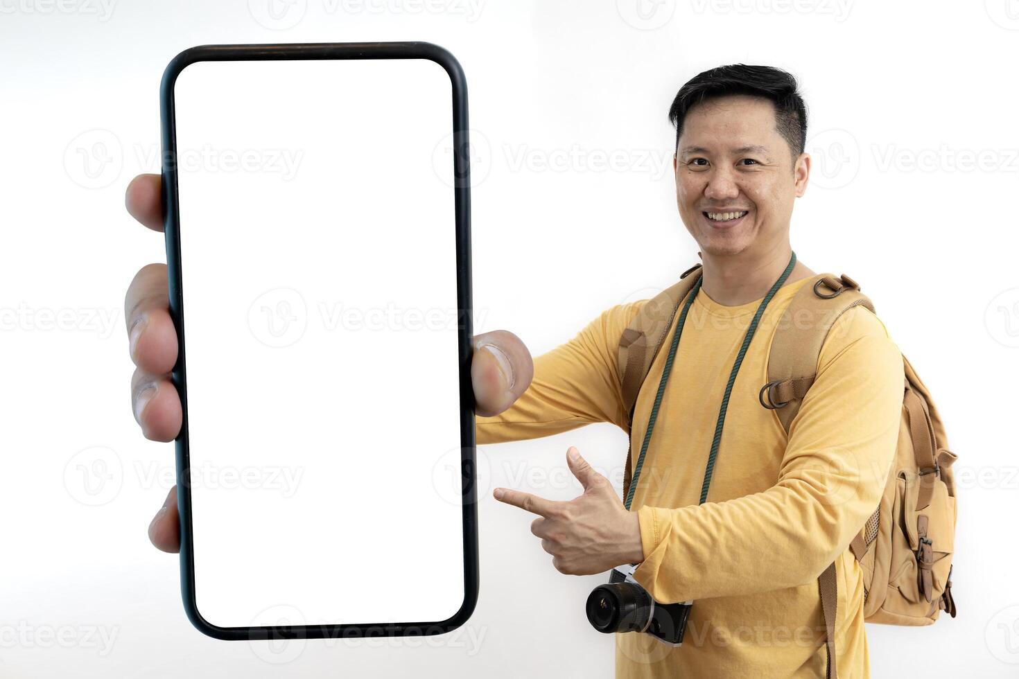 Excited tourist traveling with camera backpack and showing large empty smartphone at camera. photo