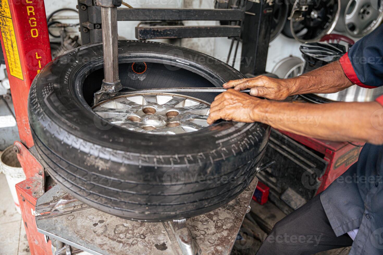 Car mechanic repairs punctured tire photo