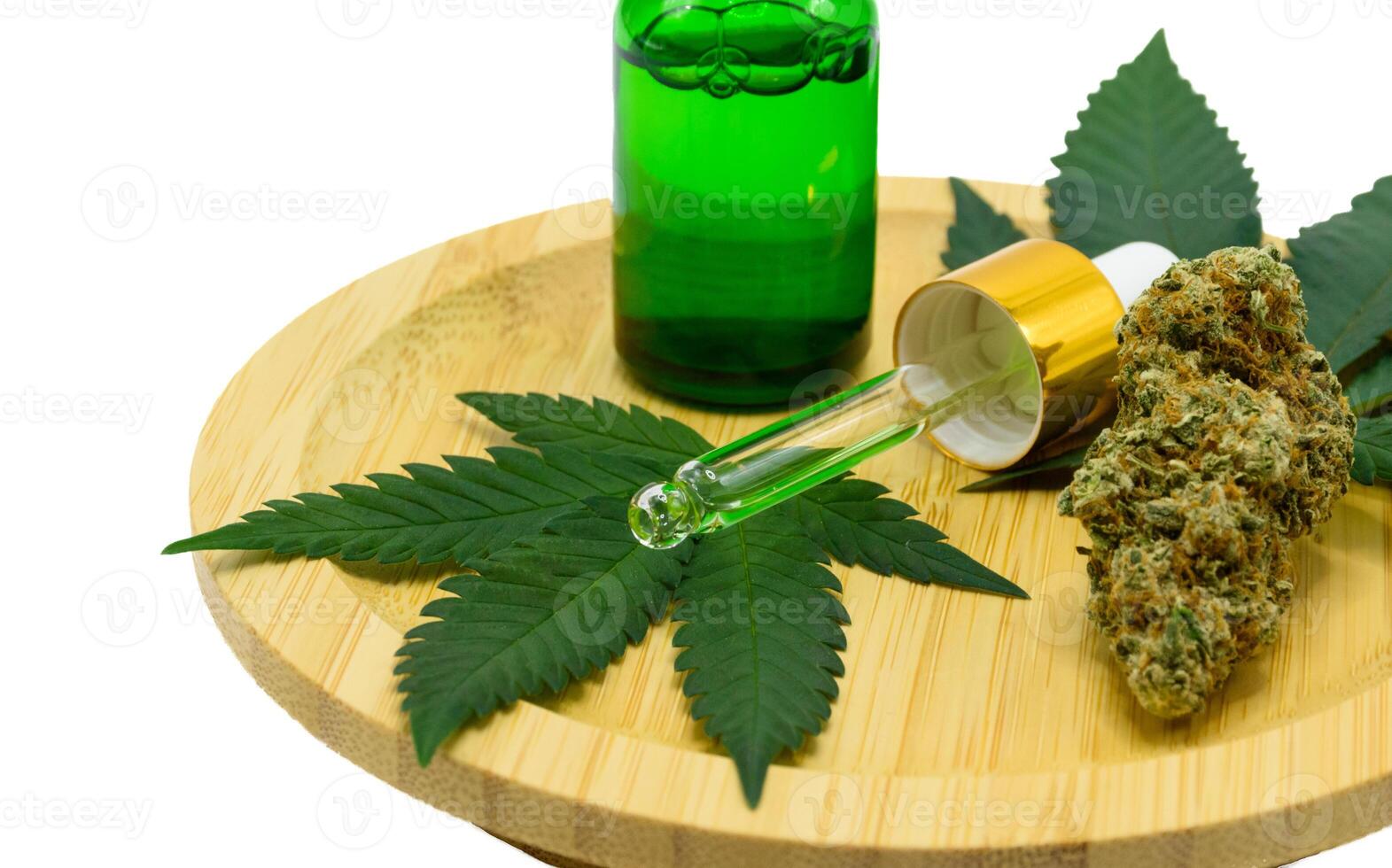 Cannabis flower buds with green dropper bottle and green leaf on a wooden plate on white isolated background, Scientists research CBD and THC extract oil from marijuana in pharmaceutical industry. photo