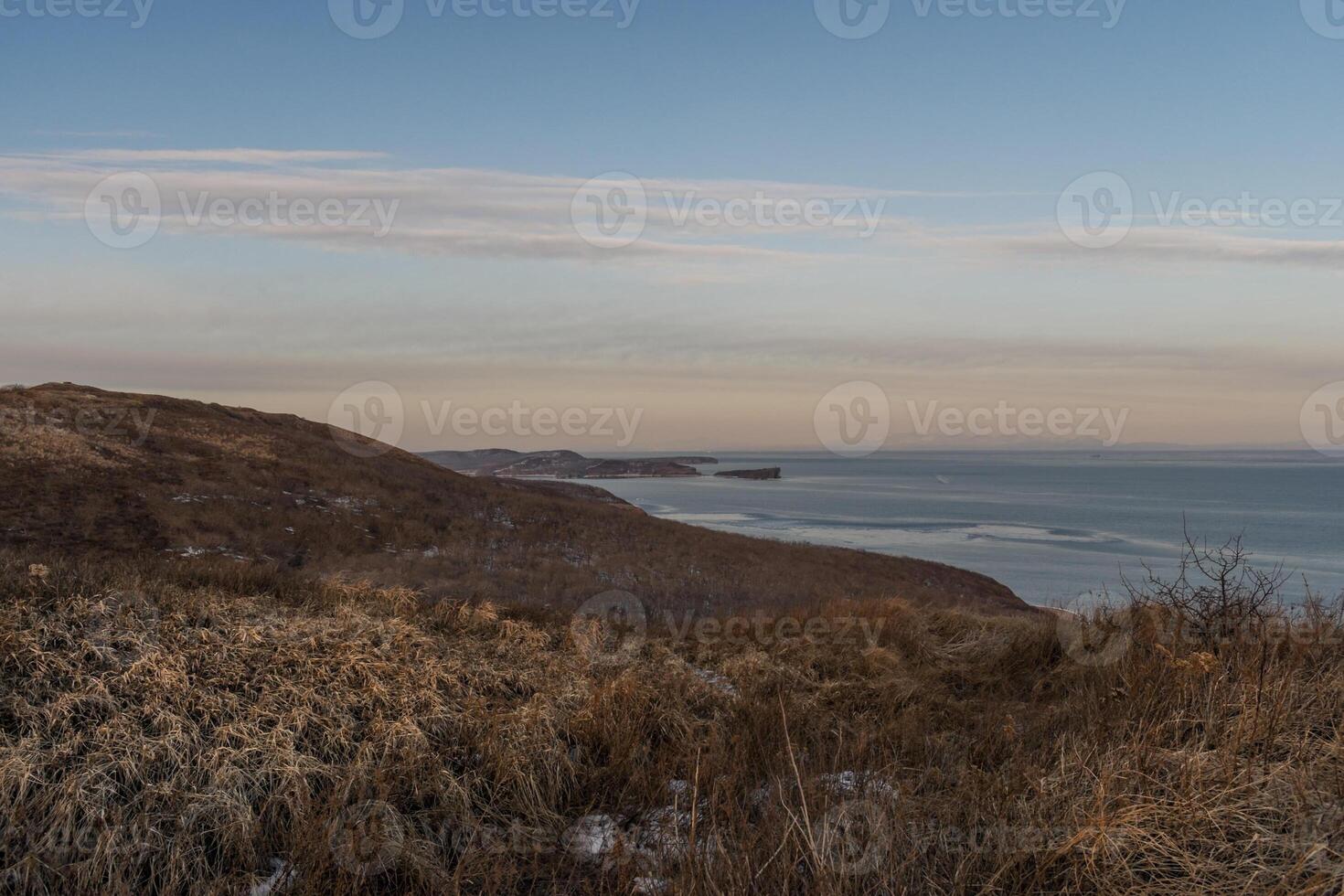 Mystical high cliffs rise above the sea. Harsh winter seascape. Place of power, calm of the elements. photo