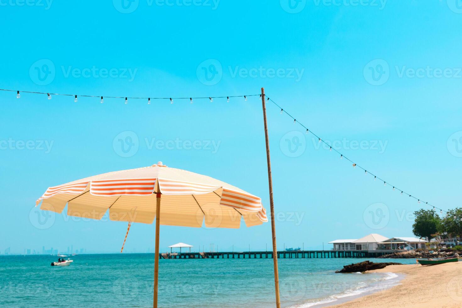 Beautiful umbrella and light bulb around tropical beach sea ocean with blue sky for travel vacation at Koh Larn island. Landscape panorama summer beach blue clean sky background morning day. photo