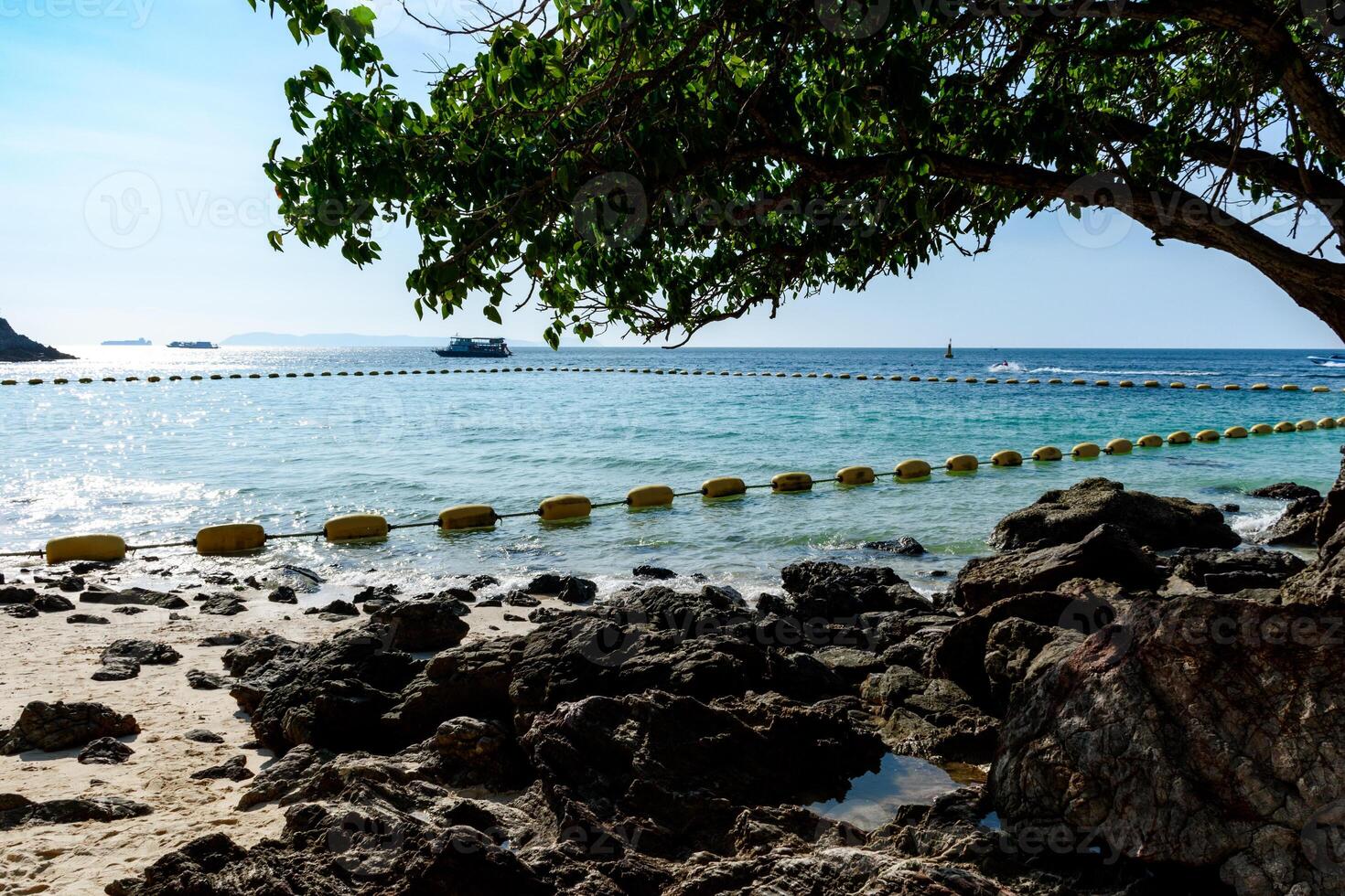 Landscape of a tropical beach with beautiful rocks in clear blue water sea and waves on a clear sky sunset background morning day at Koh Larn island. Panorama ocean. Pattaya, Thailand, Boat, Vacation. photo