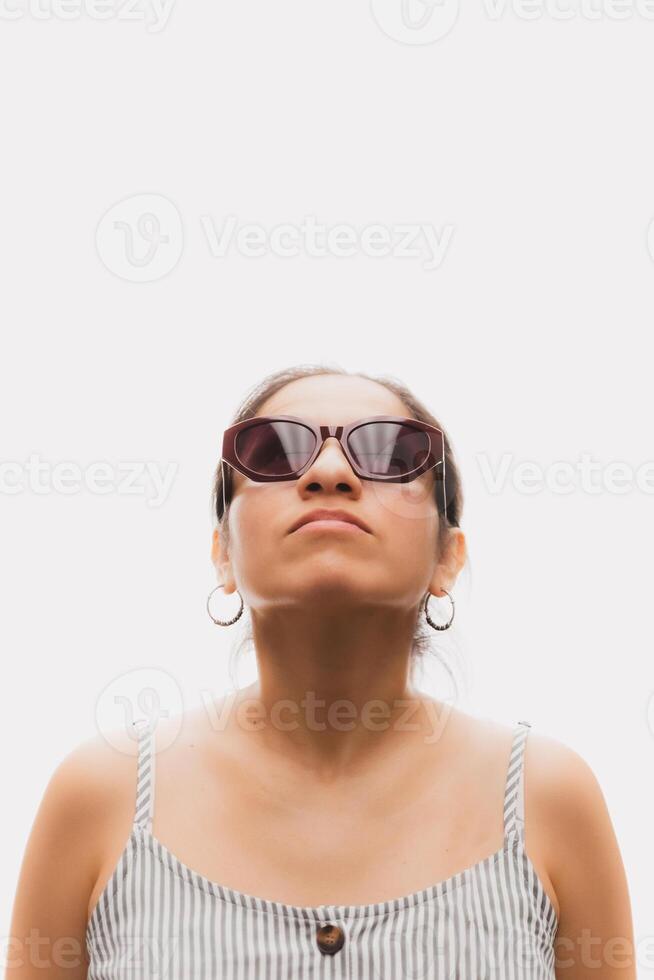 Woman with glasses in front of a white background and looking up photo