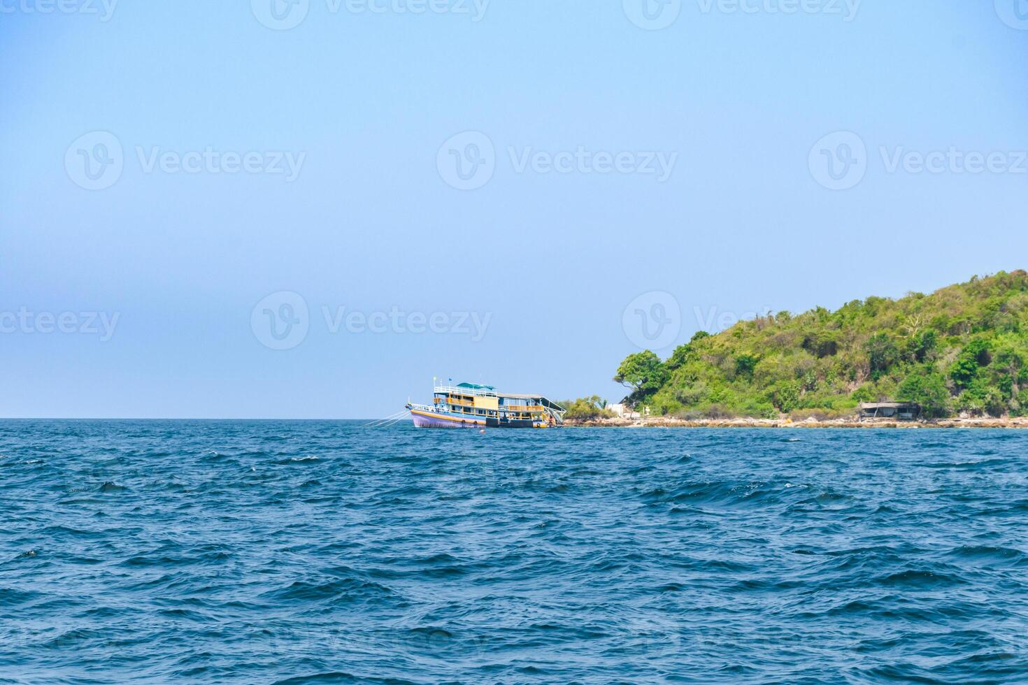 Boat sailing on the blue tropical sea on the background of island and clear blue sky morning day at Koh Larn island. Ferry ship running on the bay, Panorama ocean, Pattaya, Thailand, Vacation. photo