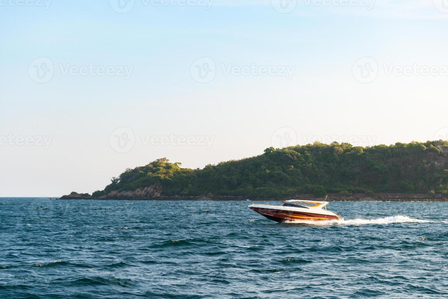 Speedboat sailing on the blue tropical sea on the background of island view and clear sky sunset day at Koh Larn island. Speed boat running on the bay, Panorama ocean, Thailand, Vacation. photo