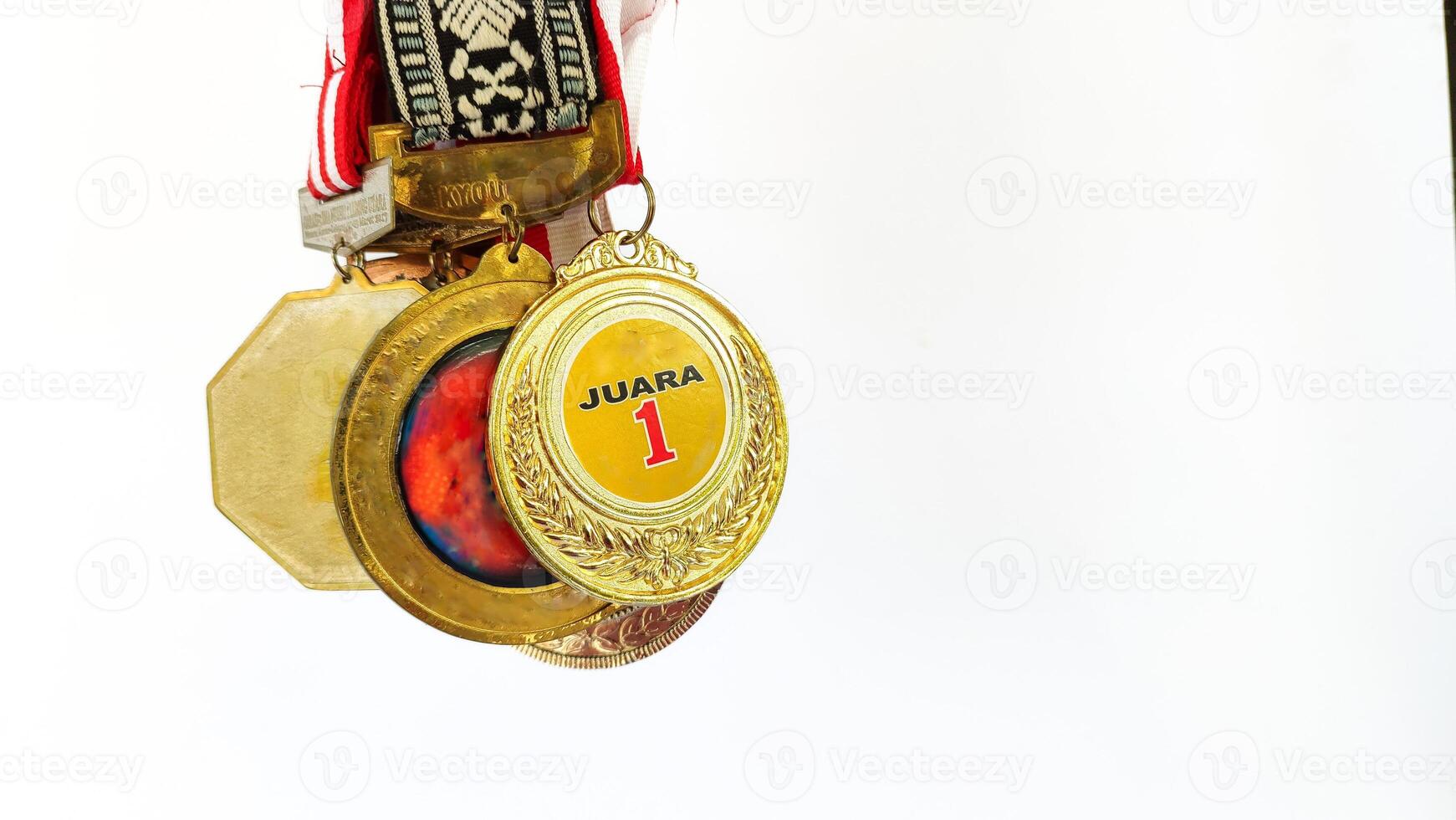 The winner's gold medal is held in the athlete's raised hand on a white background photo