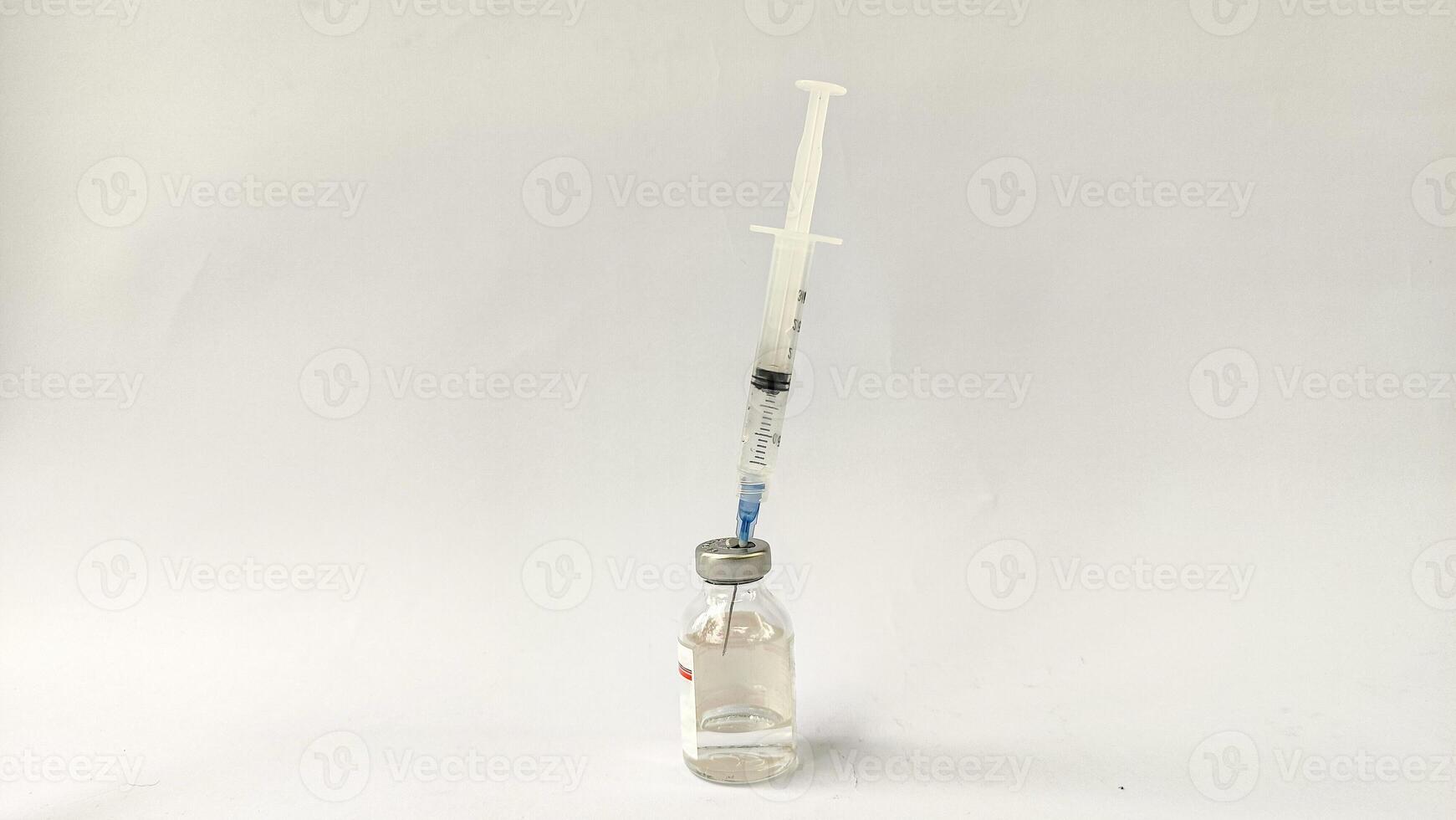 Vial of Drug or Vaccine and 3 ml Plastic Syringe with Needle Isolated on the White Background, blue tone color photo