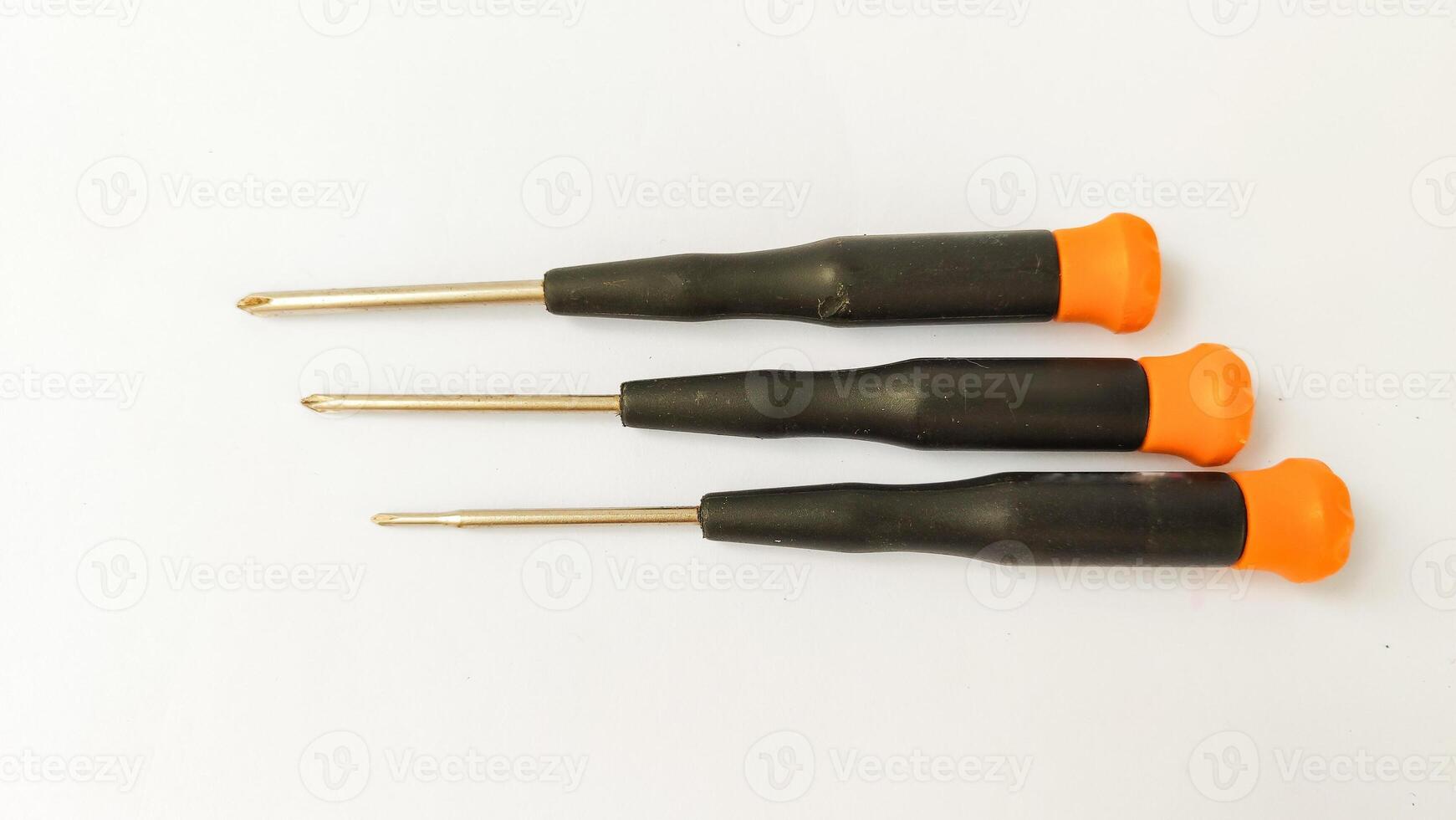 Set of red-orange-blue screwdrivers isolated on white background. Builder's and electrician's tools. Equipment. Set of steel screwdriver bits with red and black plastic handles. photo
