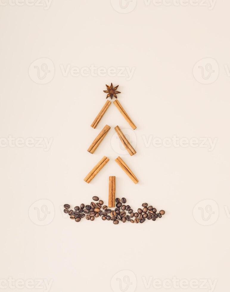 Christmas tree made of coffee beans, cinnamon sticks and star anise on pastel cream background. Minimal Christmas and New Year concept. Creative festive holiday layout. Flat lay. photo