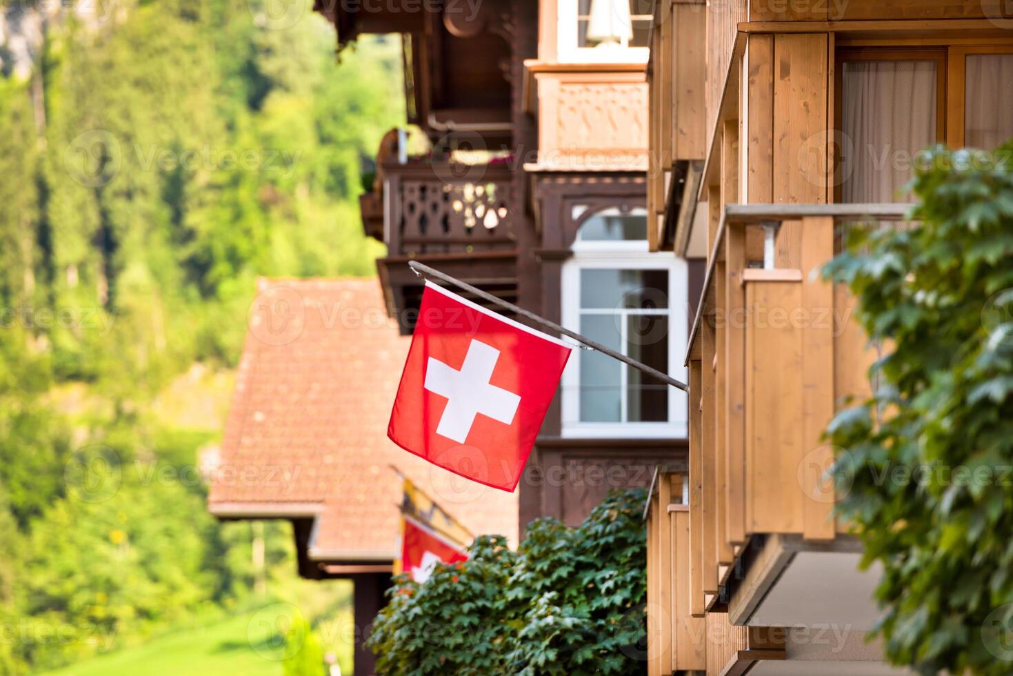 Fluttering Red Swiss flag on wooden house photo