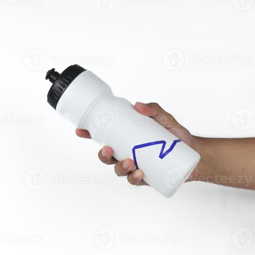 Hand holding a sports water bottle isolated on white background photo