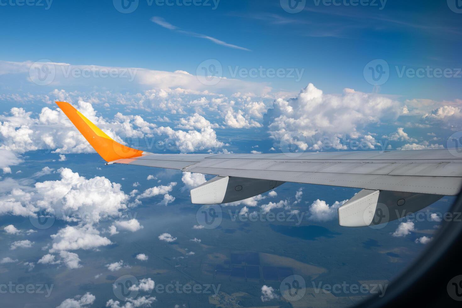 View from airplane window on wing and landscape with clouds on window during flight. photo