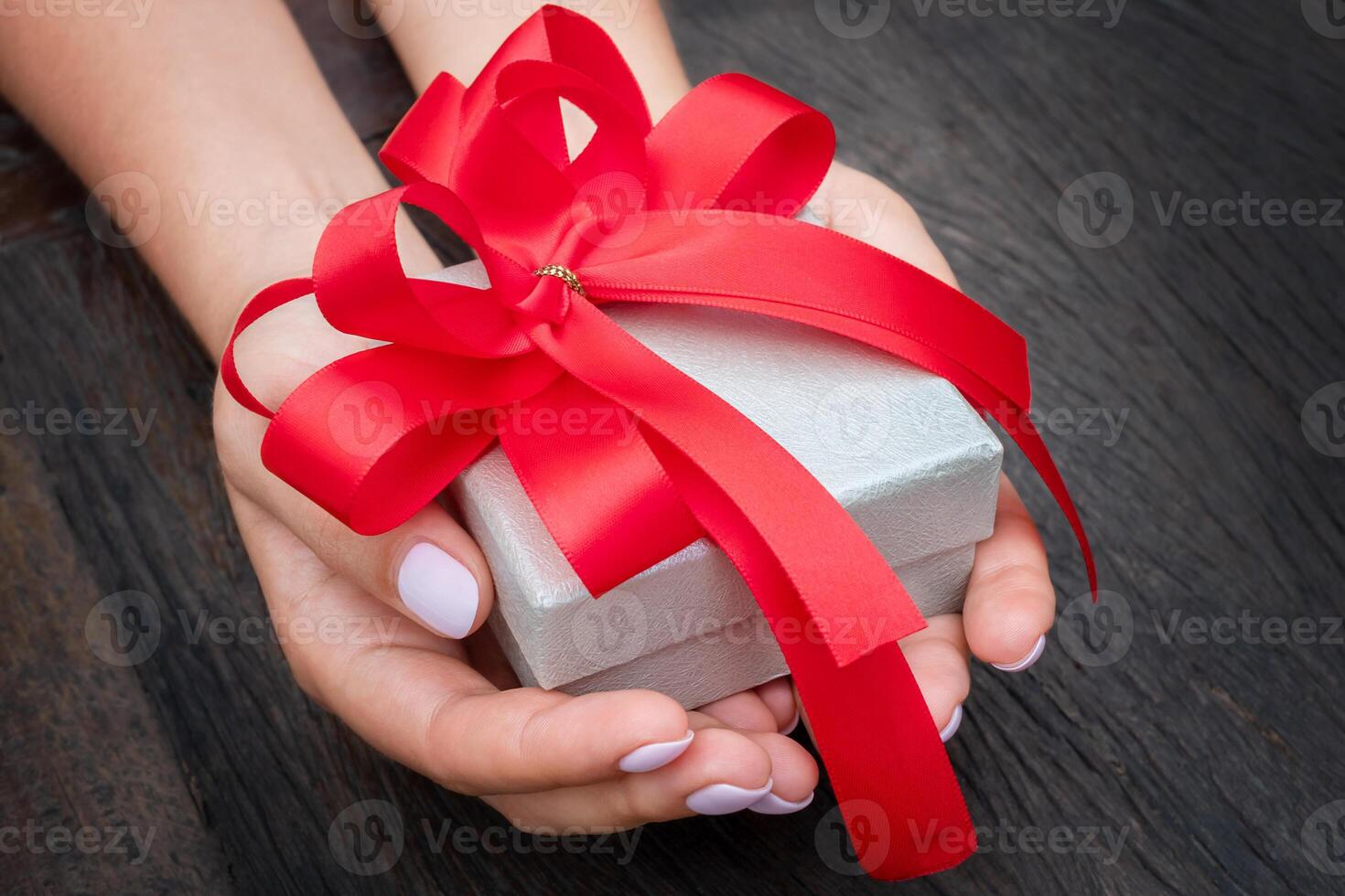 Woman holding the gift box with the red bow photo